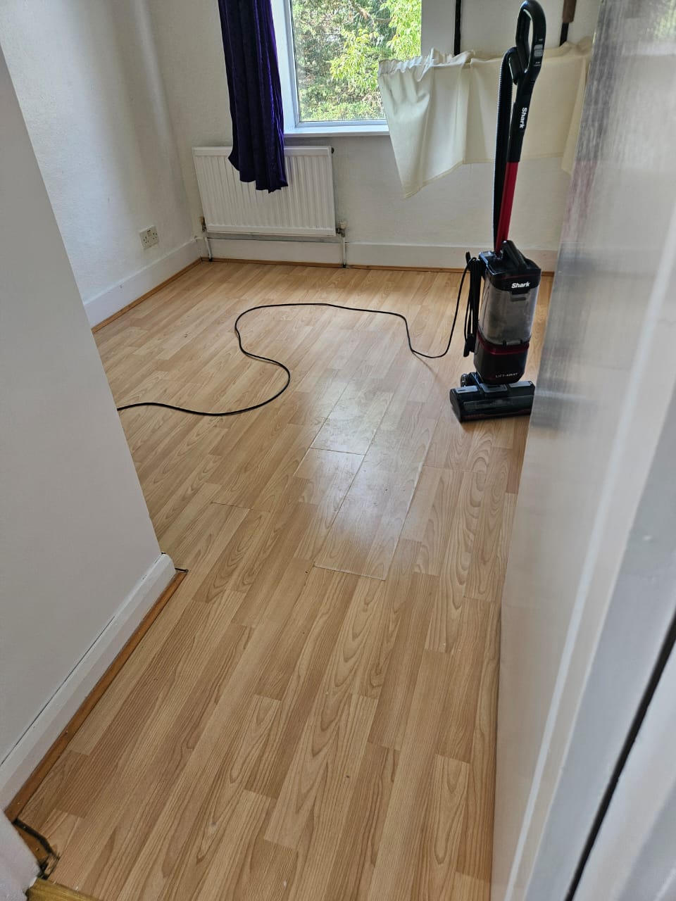 Empty room with a freshly vacuumed laminate floor after an ST HECS end of tenancy clean